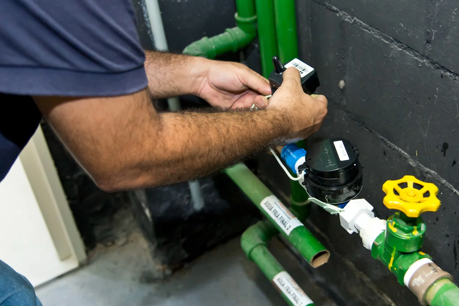 Técnico da Hidrotech instalando um transmissor de leitura remota em um hidrômetro